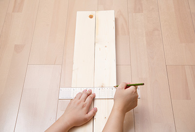 棚板を設置する位置を決めたら柱用 2×4材を平行に並べて、スケールをあてながら鉛筆で目印をつけます